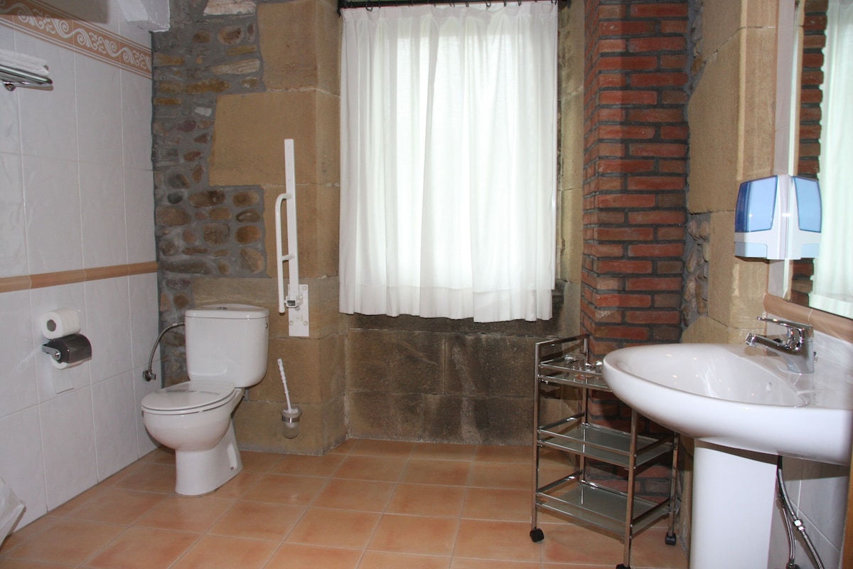 Un baño con inodoro, lavamanos y cortina de ducha.