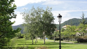 A park with a paved path, benches, and a street lamp. - Hotel Palacio Atxega (Usurbil)