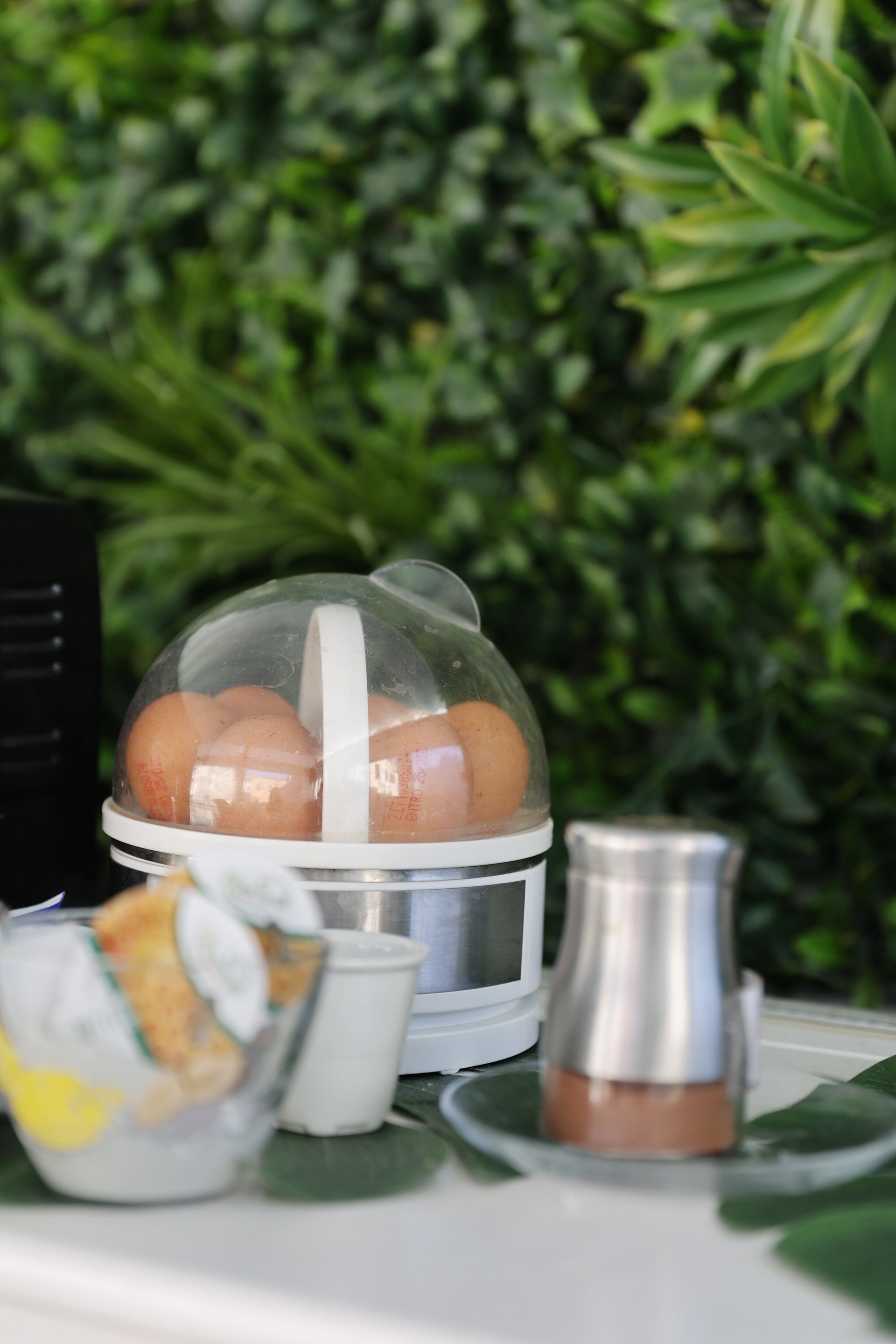 A breakfast setup with eggs, a coffee pot, and a yogurt container.