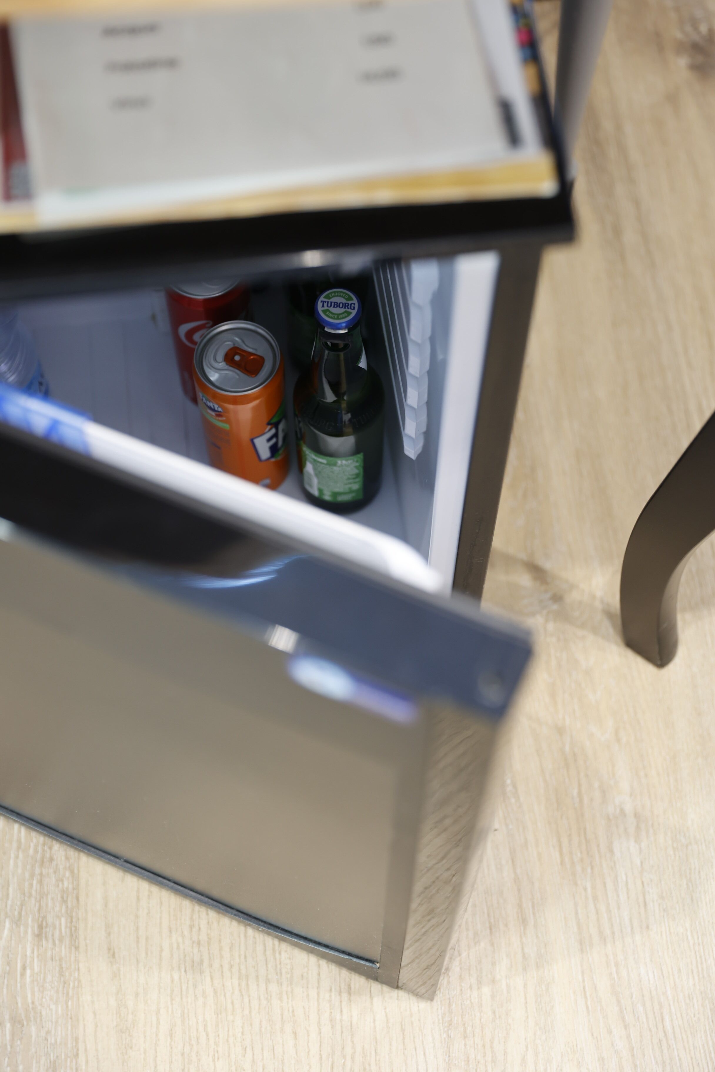 A drawer with a can of Fanta and a bottle of Tuborg beer.