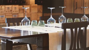 Un bar con estantes llenos de botellas de vino y copas sobre una mesa.