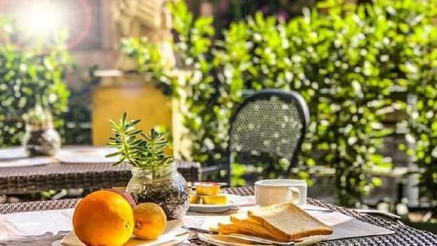 A table set with food and drinks, surrounded by greenery. - Aventino Guest House (Rome)