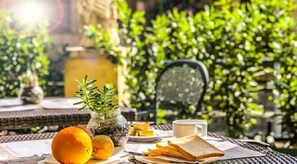 A table set with food and drinks, surrounded by greenery. - Aventino Guest House (Rome)