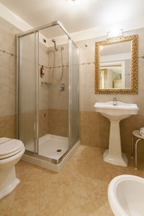 A bathroom with a glass-enclosed shower, a pedestal sink, and a toilet. - Dimora Marciana (Venice)