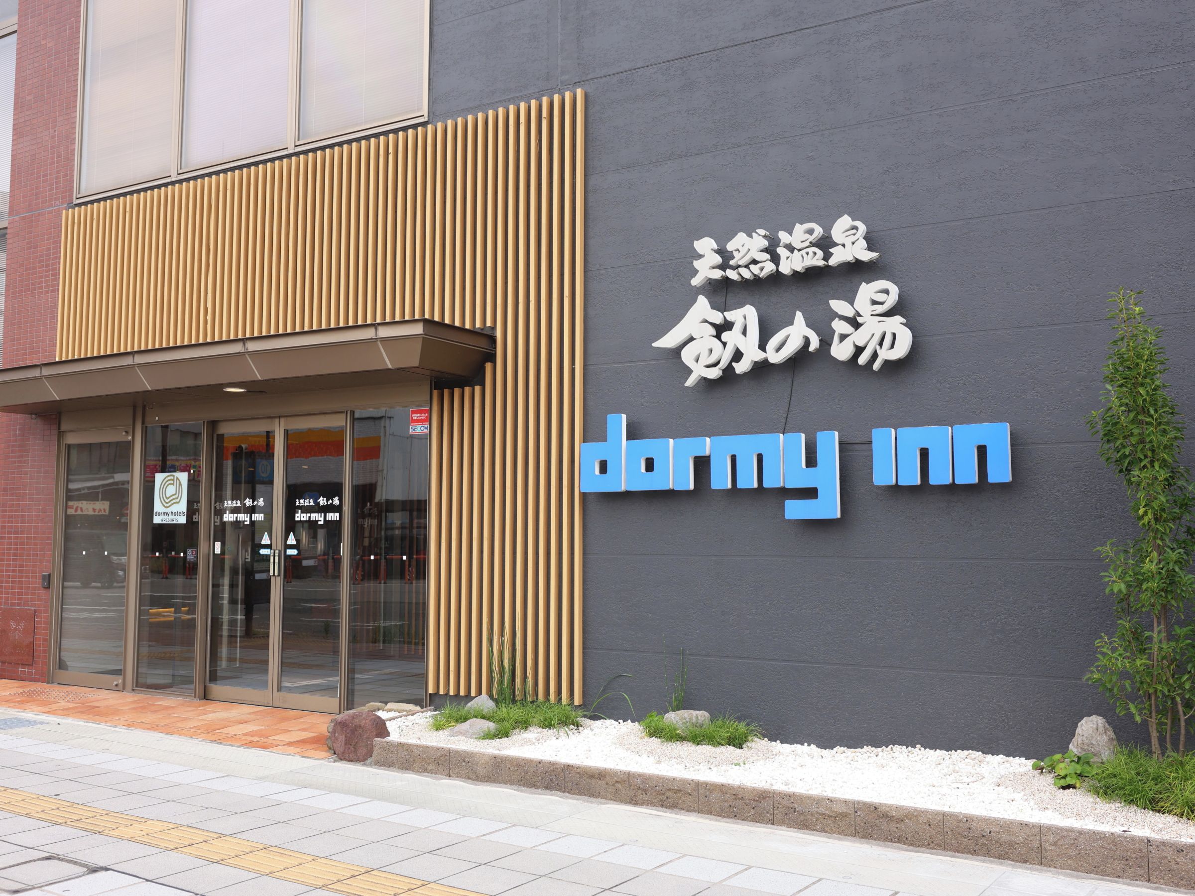 A building with a sign reading 'dormy inn' and Chinese characters above it.