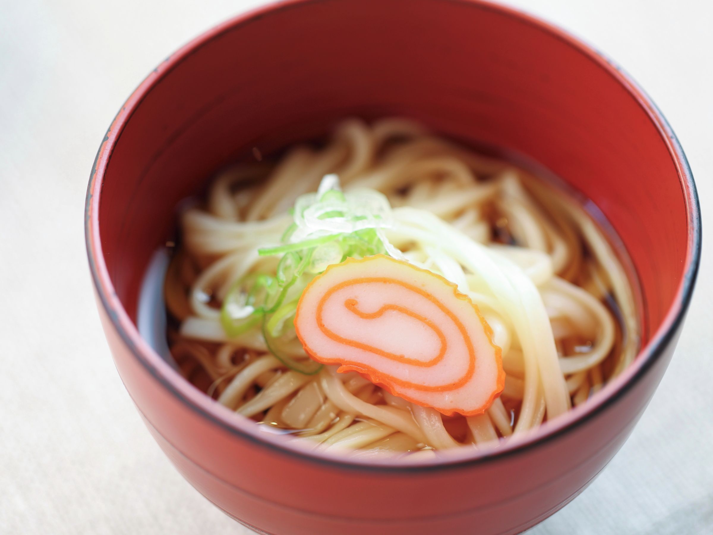 A bowl of ramen with noodles, sliced meat, and green onions.