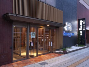 A modern building with a glass entrance and signage for 'dormy hotels & resorts'. - Dormy Inn Toyama Natural Hot Spring (Toyama)