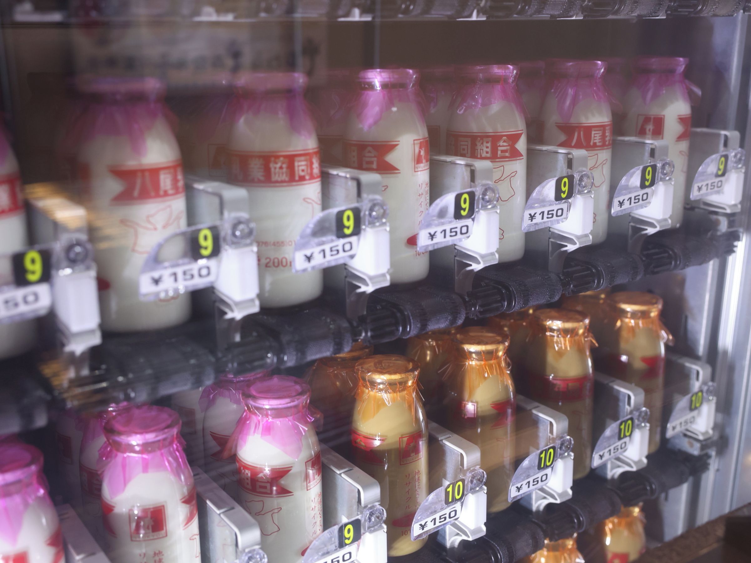 A vending machine with bottles of beverages, each with a price tag.