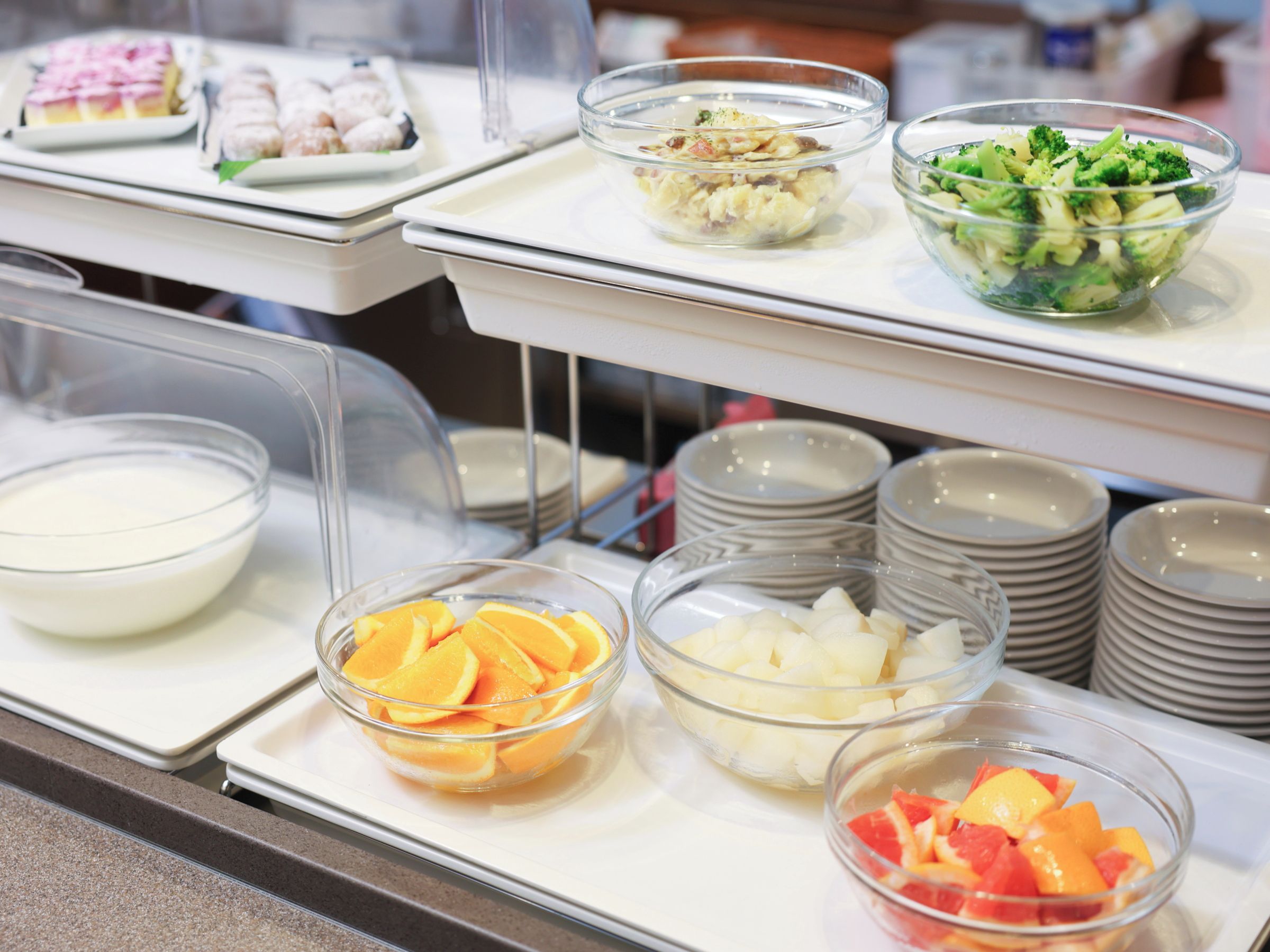 Un bufé con diversos alimentos, incluyendo frutas, verduras y postres.