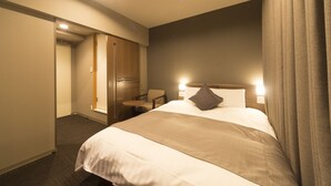 A hotel room with a large bed, a desk, a chair, and a wardrobe. - Dormy Inn Toyama Natural Hot Spring (Toyama)