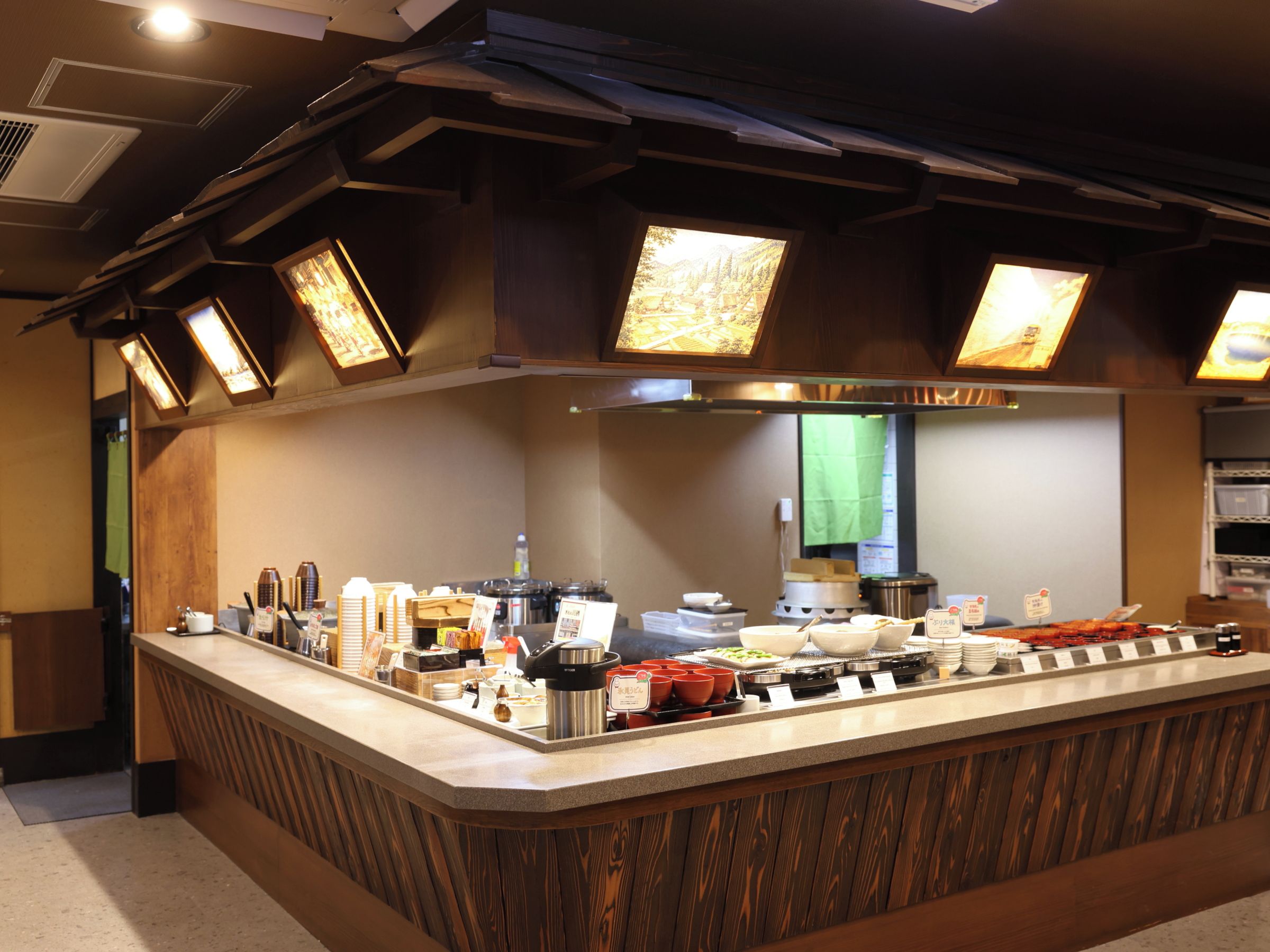 A buffet counter with various food items and utensils.