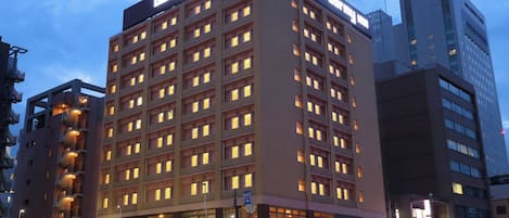 A multi-story building with a sign reading 'dormy inn' indicating a hotel.