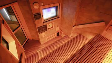 A staircase with a wooden floor and a television screen mounted on the wall.