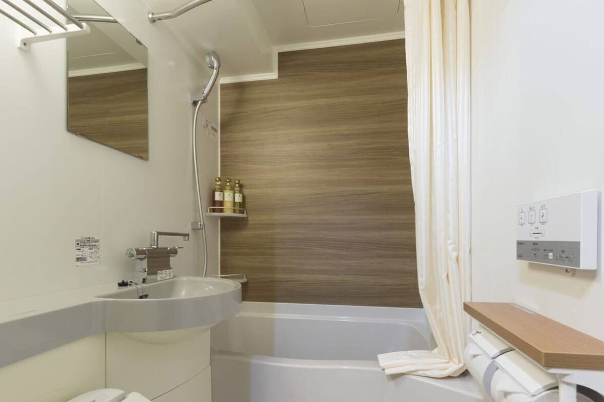 Salle de bain | Douche, séchoir à cheveux, pantoufles, bidet