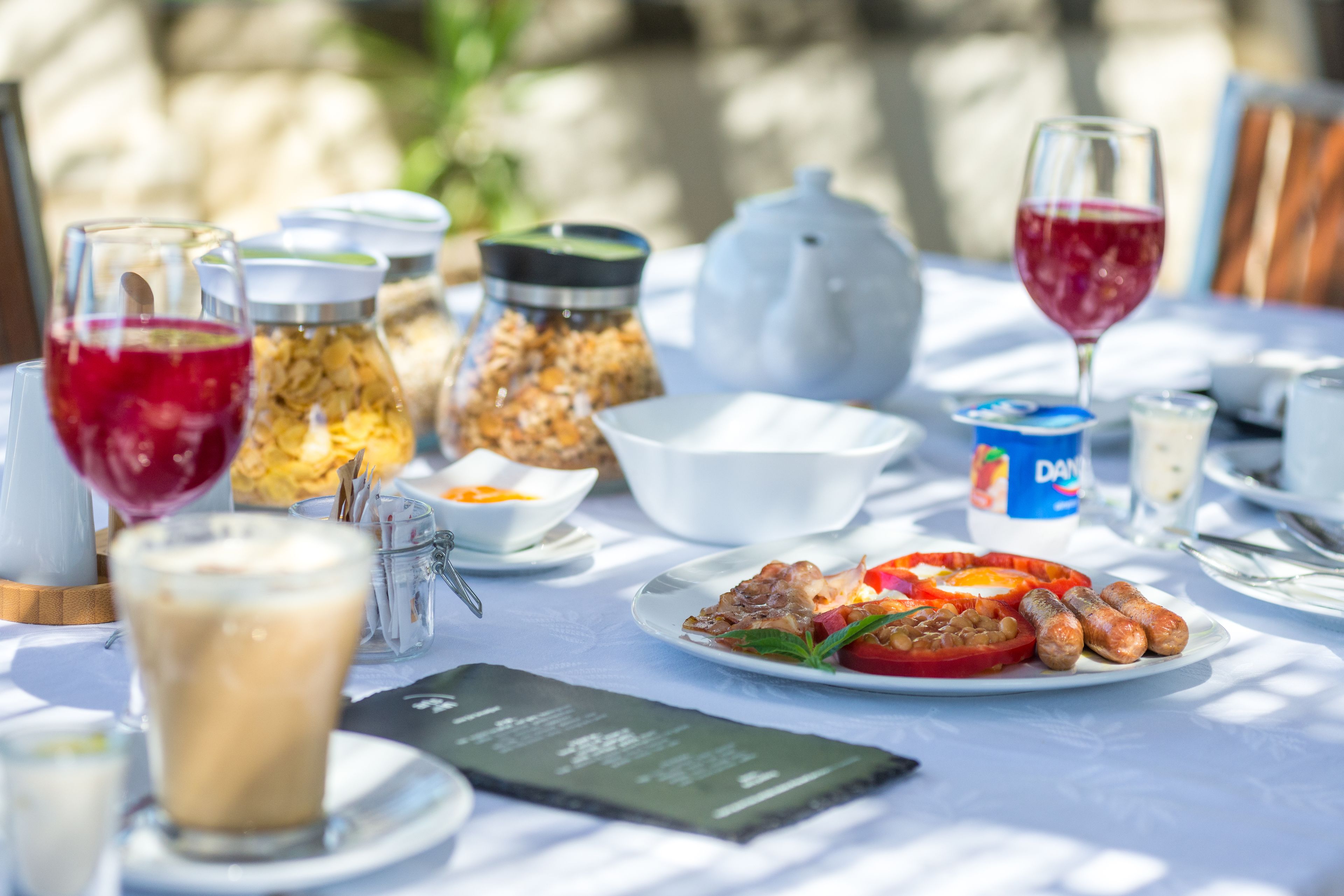 A table set with food, drinks, and condiments, suggesting a dining area.