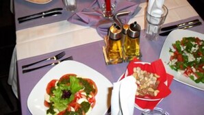 A table set for a meal with plates of food, cutlery, and condiments. - Hotel Mone (Plovdiv)