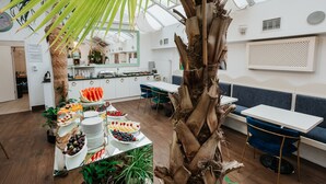 A modern interior with a central dining table, seating area, and a large plant. - Hotel Jan (Kraków)