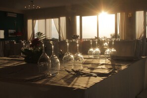 A dining table set with wine glasses and cutlery, with sunlight streaming through the windows. - Poggio degli Ulivi (Rodi Garganico)