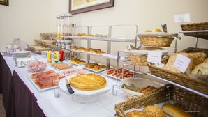 Een buffet met verschillende gerechten en een taart op een presentatiestandaard.