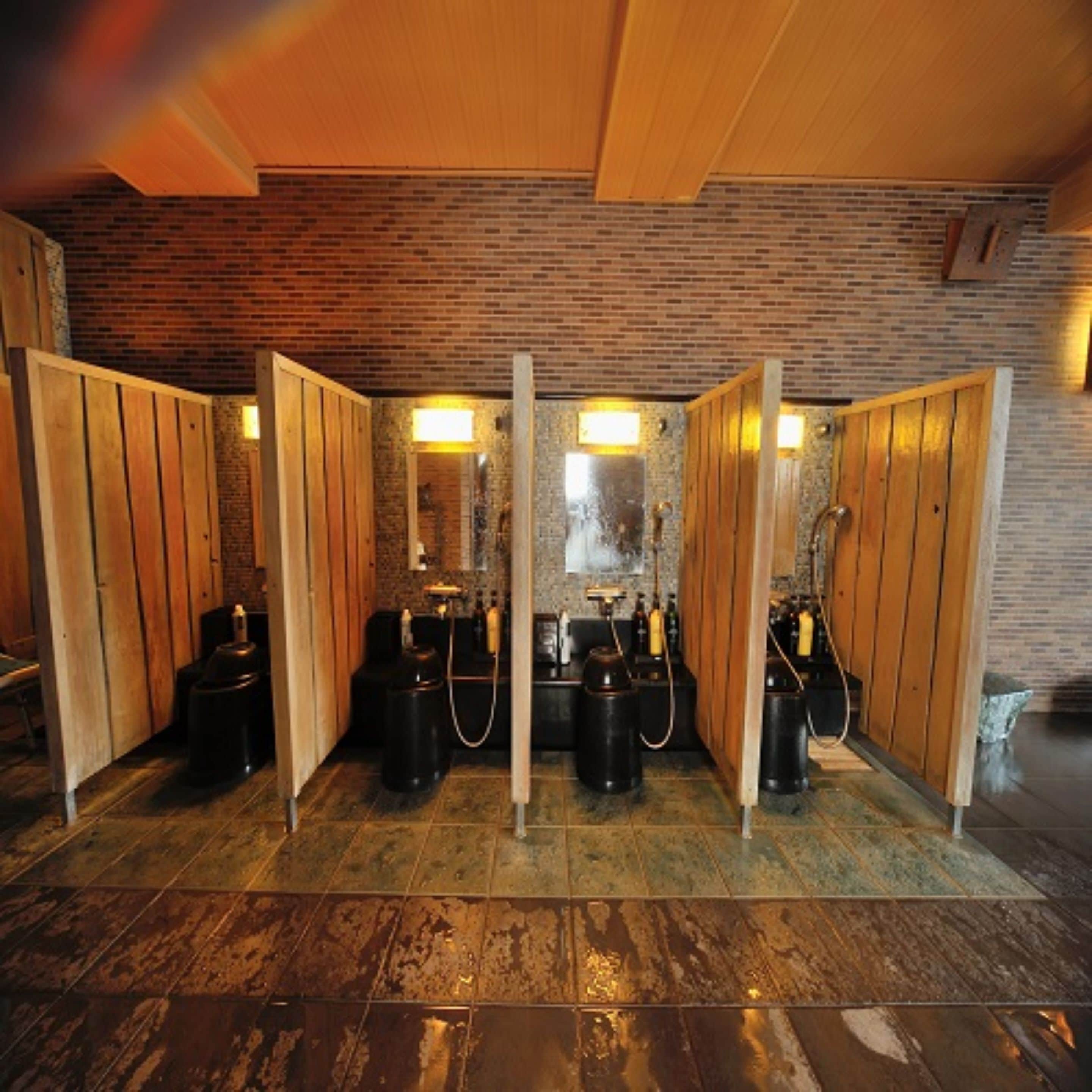 A spa area with wooden partitions, a brick wall, and gas cylinders.