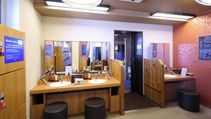 A public restroom with wooden counters, mirrors, and black waste baskets. - Dormy Inn Matsumoto Natural Hot Spring (Matsumoto)