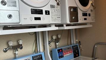 Two stacked washing machines with control panels and a water filtration system below.