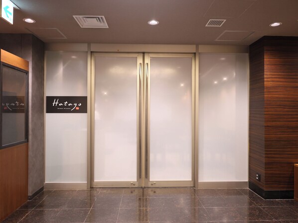 A hotel entrance with a sign reading "Hatago Global Kitchen".