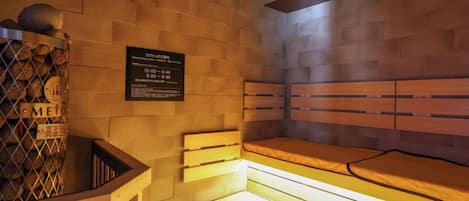 A sauna with a wooden bench and a wall-mounted sign with operating hours.