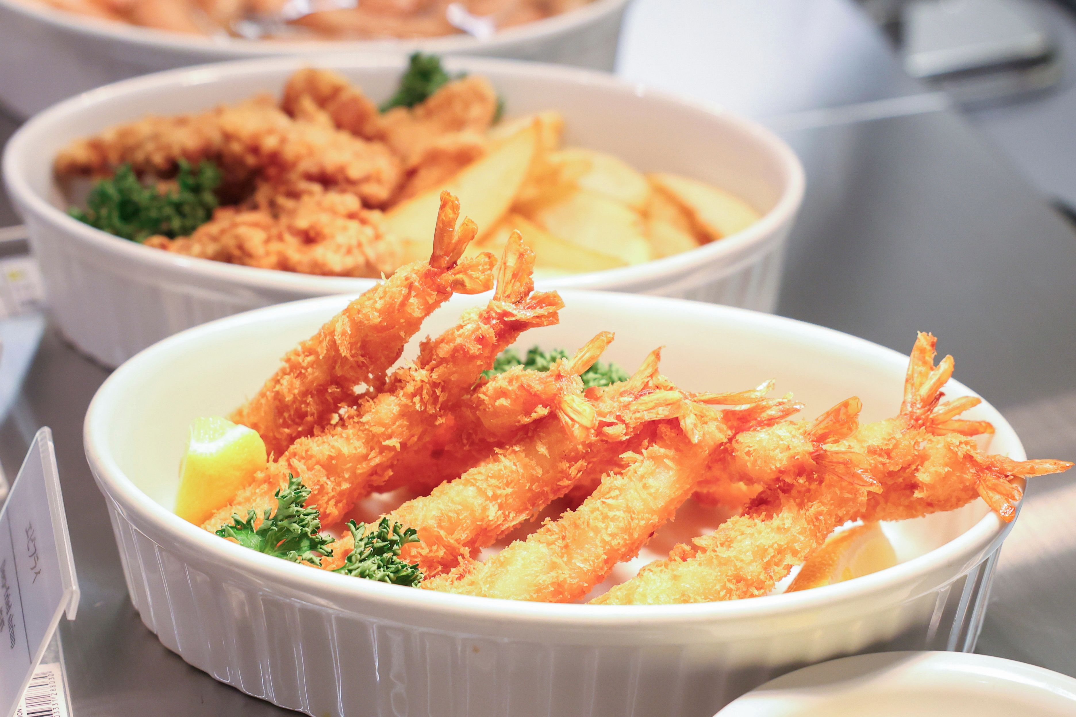 A bowl of tempura shrimp with lemon wedges and parsley garnish.