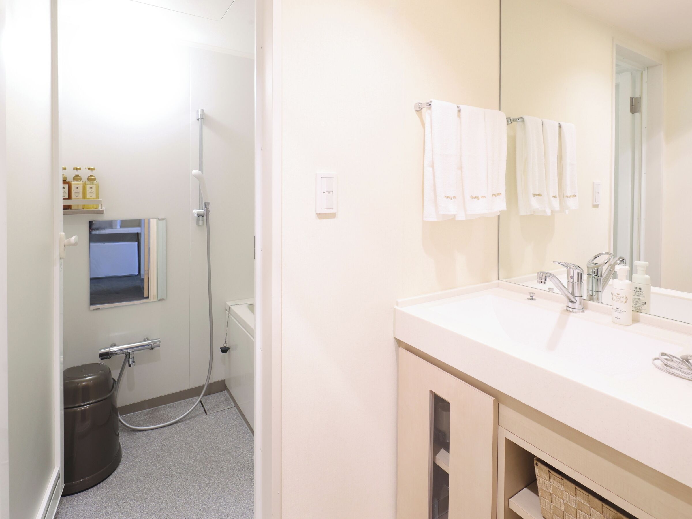 A bathroom with a shower, a sink, a mirror, and a toilet.