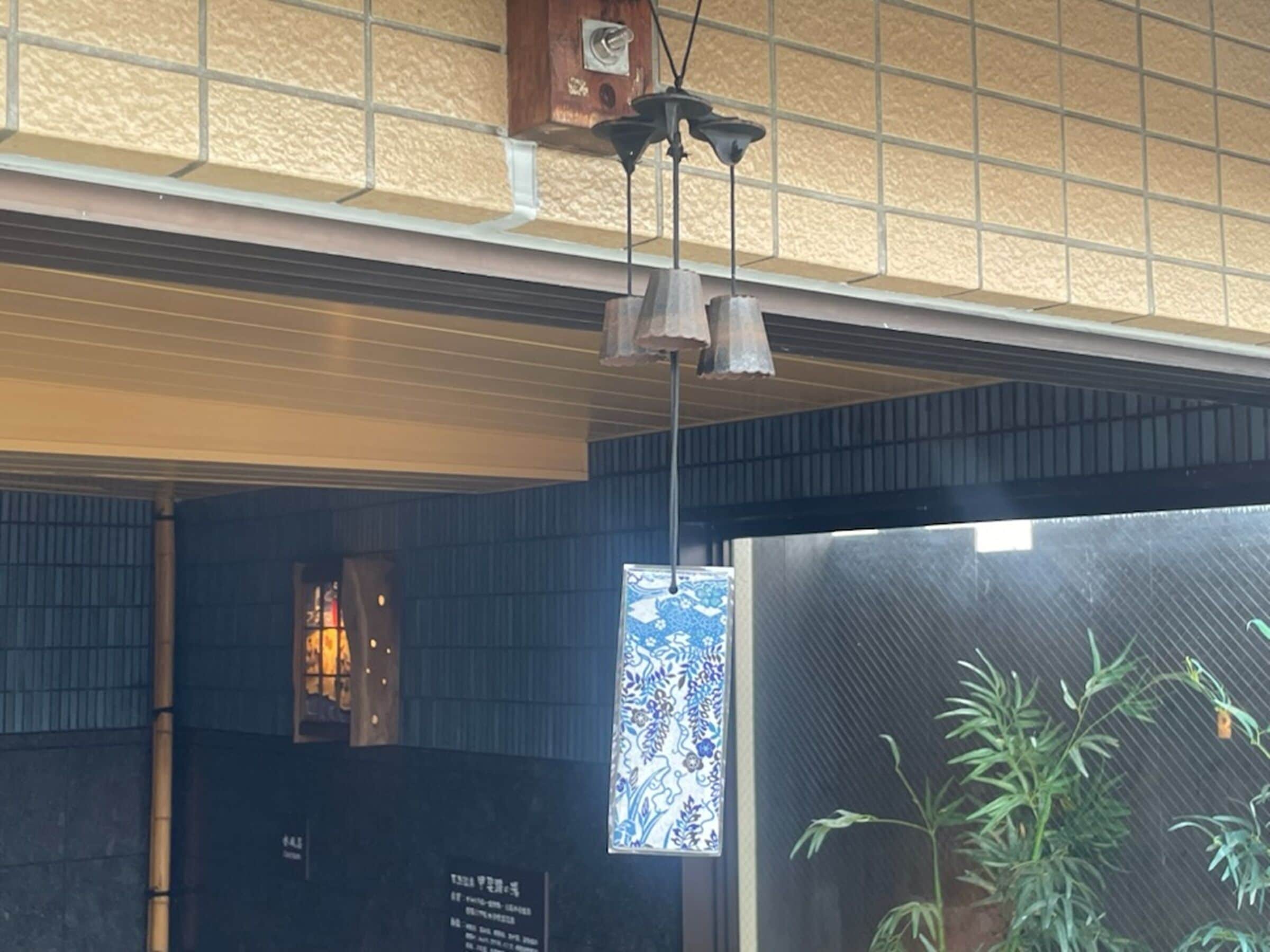 Una habitación con techo de baldosas, lámpara colgante, ventana con vista decorativa y una planta.
