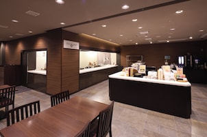 A modern restaurant with a central counter, seating area, and a sign on the wall.
