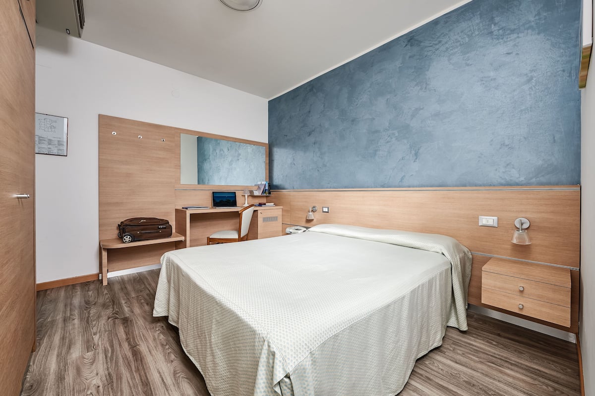 A modern bedroom with a bed, a desk, and a chair.