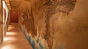 A hallway with a dragon mural on the walls. - Hotel Wawel (Kraków)