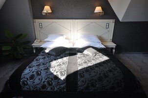 A bedroom with a bed centered between two nightstands, each with a lamp.