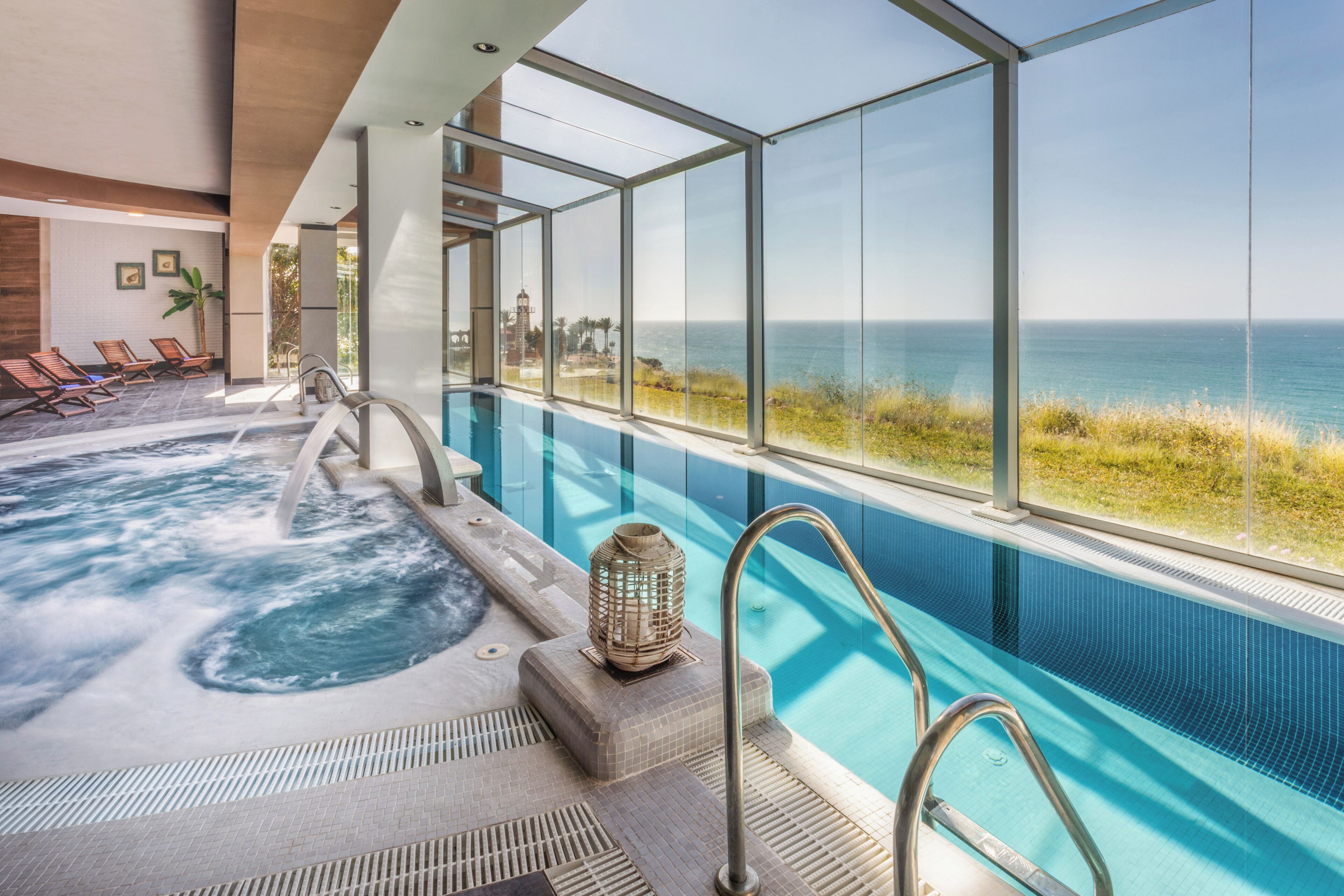 Ein Pool mit Meerblick, Liegestühlen und einem Whirlpool.