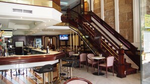 A bar area with a counter, stools, and a television screen. - Hotel Compostela Vigo (Vigo)