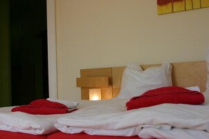 Una habitación de hotel con una cama, almohadas y una mesita de noche.