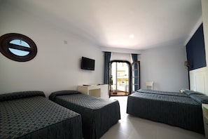 Ein Hotelzimmer mit zwei Betten, einem Schreibtisch, einem Fernseher und einem Balkon.