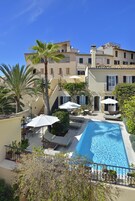 Una piscina al aire libre, sombrillas, tumbonas