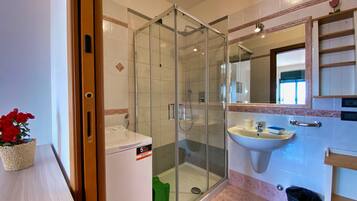 Une salle de bain avec une douche à parois de verre, un lavabo et des toilettes.