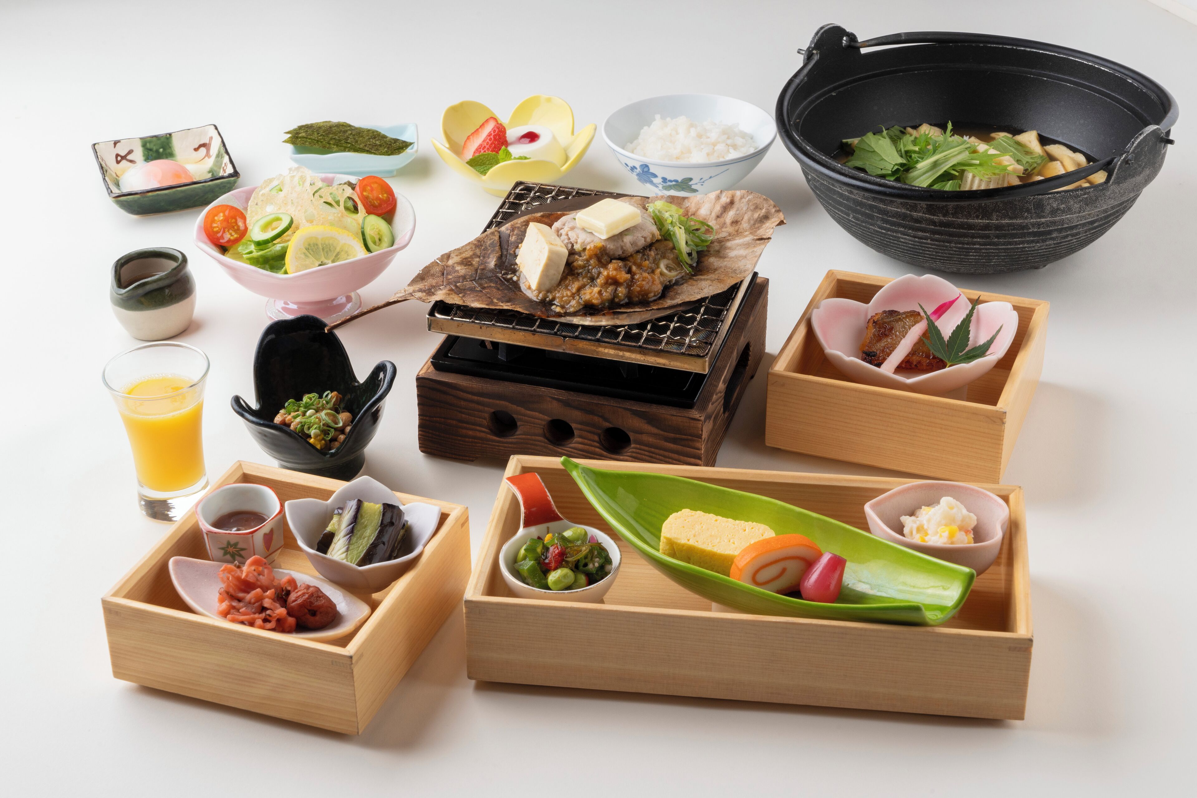 A variety of wooden trays and bowls containing different food items, arranged on a white surface.