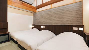 A bedroom with two beds, wooden headboard, and a skylight.
