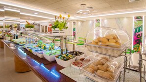A buffet with various food items and a decorative plant arrangement. - Hotel Servigroup Romana (Alcala de Xivert)