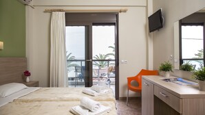 A hotel room with a bed, a desk, a chair, a TV, and a balcony with a view.