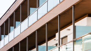 A modern building with a series of balconies and large windows.