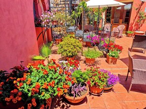 A patio with potted plants and outdoor furniture. - Hotel Il Vecchio Mulino (Tortoli)