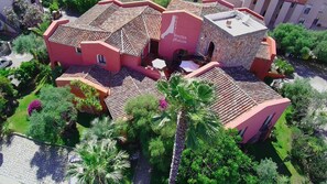 A hotel with a red facade, terracotta tiled roofs, and a stone structure. - Hotel Il Vecchio Mulino (Tortoli)