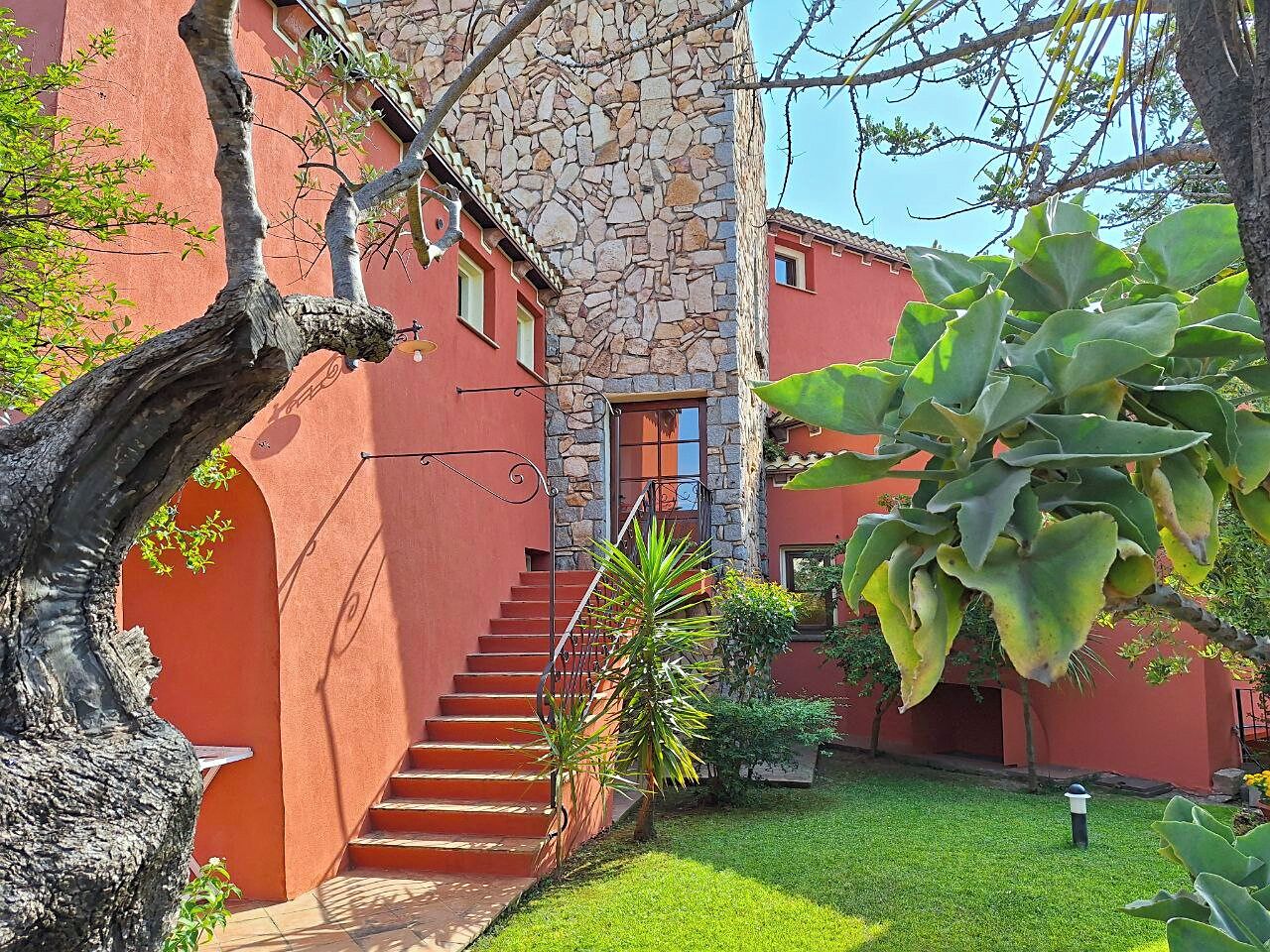 Un edificio con fachada de piedra, exterior rojo y una escalera que lleva a una puerta.