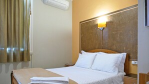 A hotel room with a bed, a nightstand, a lamp, and a window with curtains. - Guest House São Filipe (Faro)